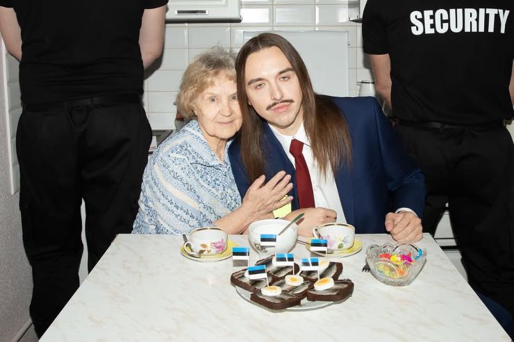 Tommy Cash seduto a un tavolo insieme a una signora anziana