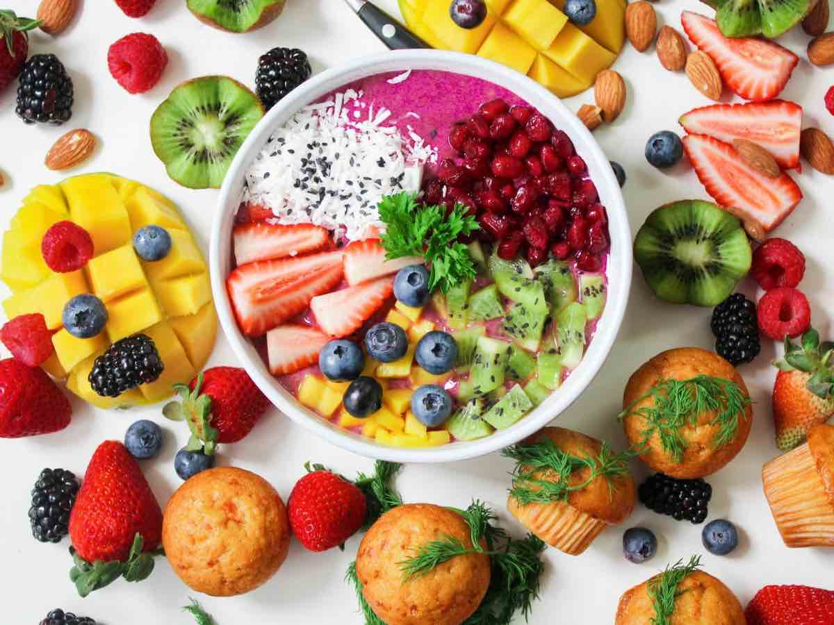 Un piatto pieno di frutta, circondato da frutta