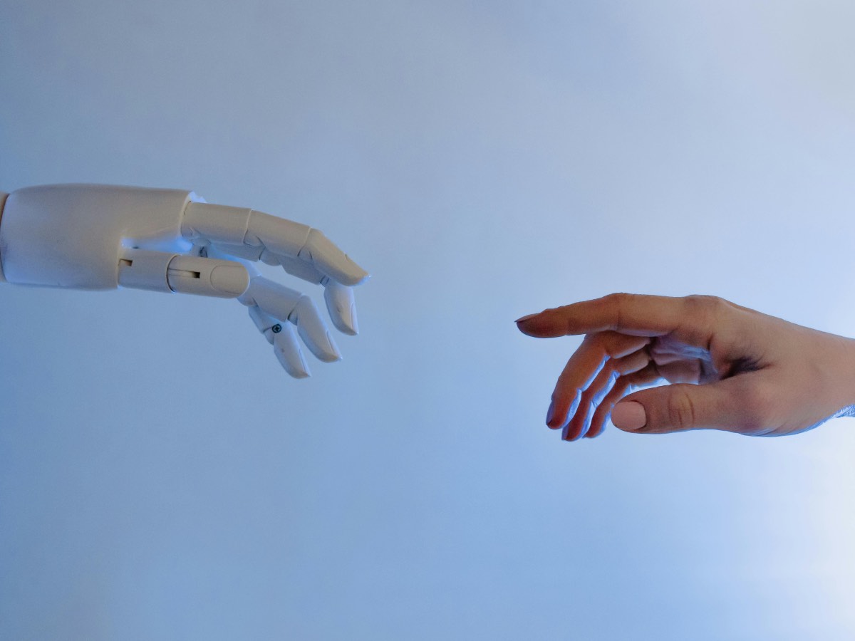 Mano di un robot che si avvicina a una mano umana