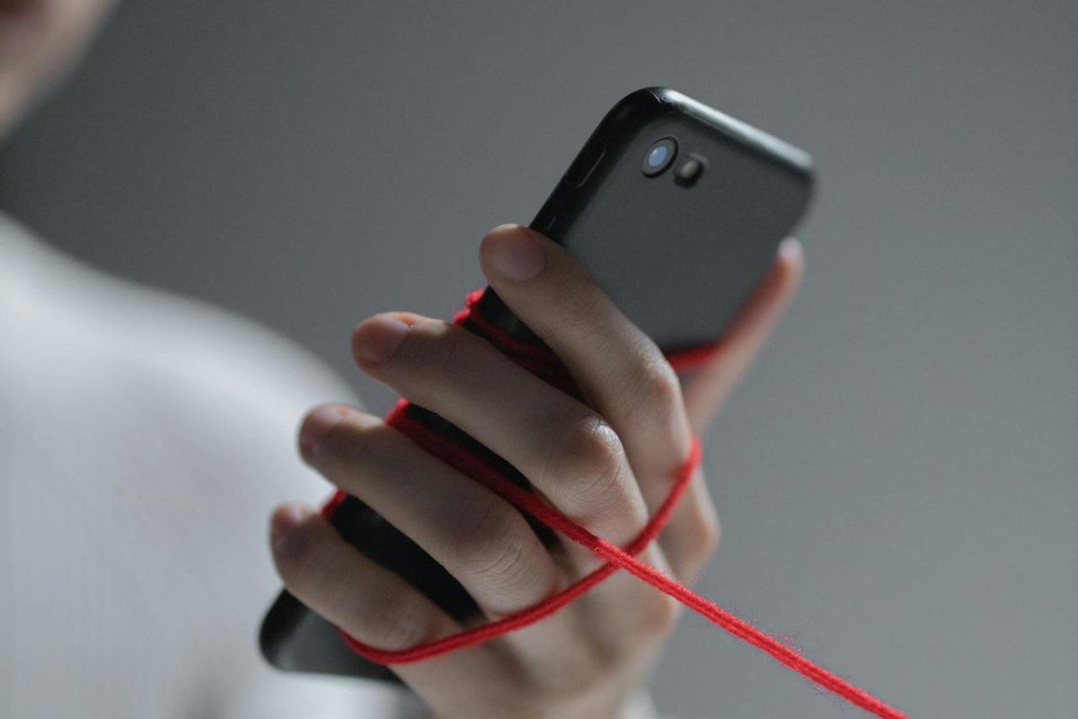 Smartphone legato alla mano