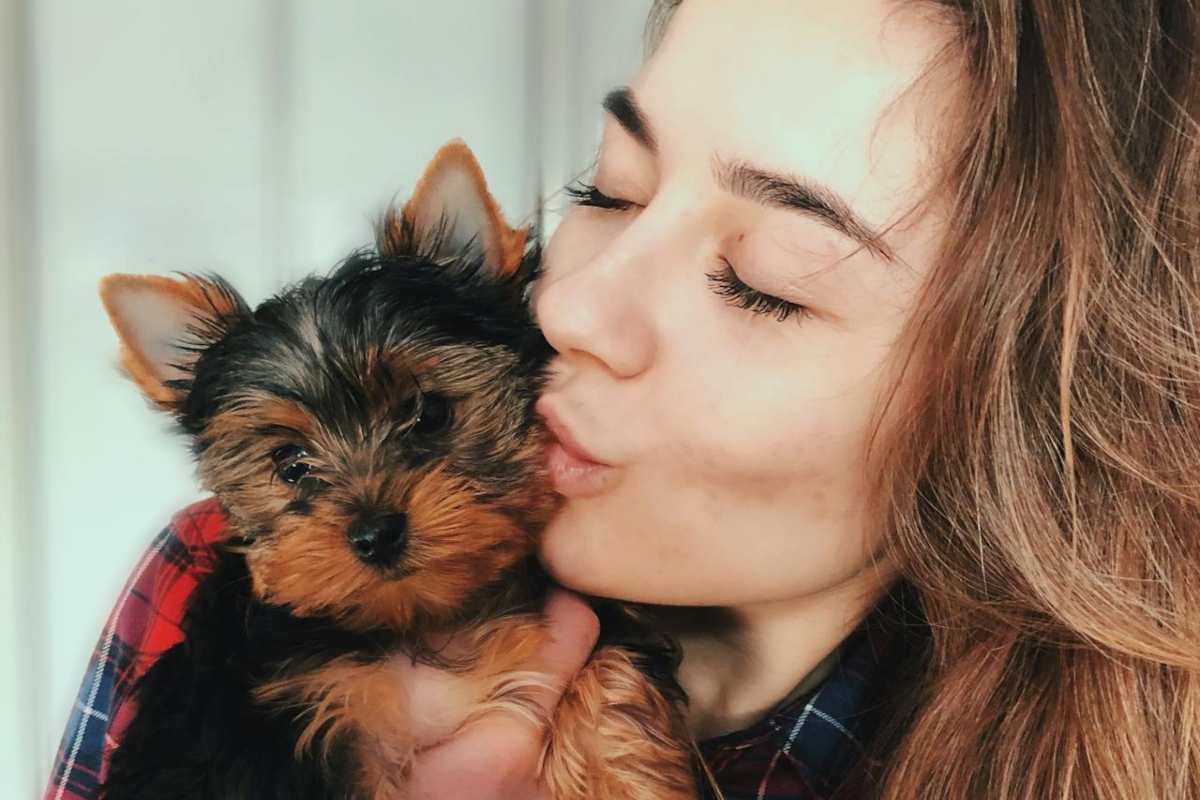 Ragazza che bacia un cane