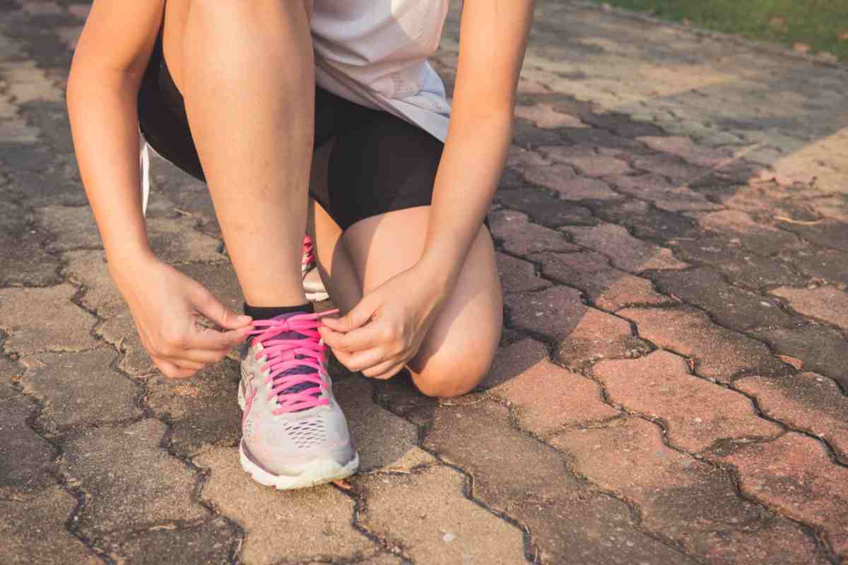 Ragazza che si allaccia le scarpe prima di correre