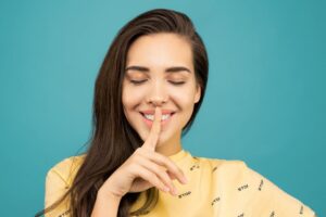 Ragazza che fa segno del silenzio con il dito
